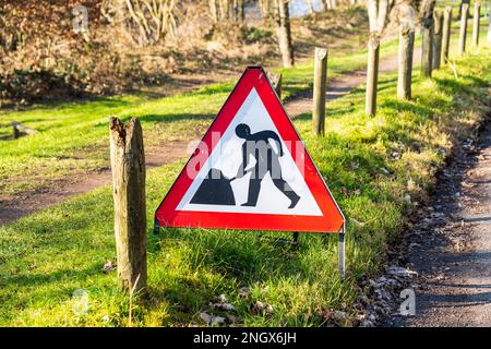 Verkehrsschild in Großbritannien mit der Aufschrift „Road works ahead“ auf einem rot-weißen Warndreieck Stockfoto