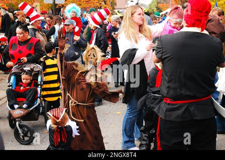 Familien versammeln sich in Kostümen und sind bereit für eine Halloween Parade Stockfoto