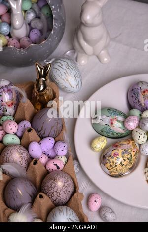 Foto von Wachteln und Hühnern dekorative Eier, die in einem Behälter auf dem Tisch liegen Stockfoto