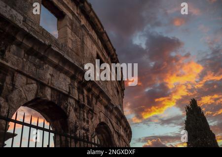 Römisches Amphitheater mit dramatischem Sonnenuntergang in Kroatien. Pula Arena während der Golden Hour. Berühmtes Denkmal in Istrien. Stockfoto