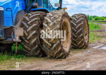 Verschmutzte Doppelräder des Landwirtschaftstraktors am Sommertag Stockfoto