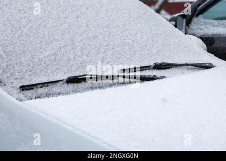 Schneebedeckte Windschutzscheibe, Scheibenwischer und Motorhaube Stockfoto