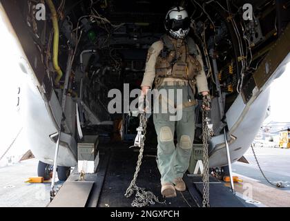 221130-N-IV962-1021 PAZIFIK (30. November 2022) – CPL. Jackson Blackburn, ein Besatzungschef, der Marine Medium Tiltrotor (VMM) 362 (rein.) zugewiesen ist, bewegt Ketten vor dem Start während des Flugquartiers an Bord des Amphibienschiffs USS Makin Island (LHD 8), 30. November 2022. Makin Island soll eine integrierte amphibische Truppe einsetzen, die die Einsatzkommandos auf der ganzen Welt sowohl mit Streik- als auch mit amphibischen Fähigkeiten unterstützen kann. Makin Island Amphibious Ready Group, bestehend aus dem Amphibienschiff USS Makin Island (LHD 8) und dem Amphibiendock USS Anchorage (LPD 23) und den USA Stockfoto