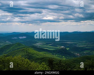 Luftaufnahme einer weißen Festung in Fuzer (Füzér), Ungarn mit Wald und Hügeln, Dorf, bewölktem Wetter Stockfoto