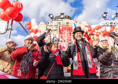 Cottbus, Deutschland. 19. Februar 2023. Cottbus Bürgermeister Tobias Schick (2. von rechts) applaudiert dem „Zug der glücklichen Menschen“ in Cottbus. Mehr als 3.000 Teilnehmer präsentieren ab 1:11 Uhr fast 60 Bilder aus der Region, aus Berlin und aus Sachsen. Tausende von Besuchern sehen die größte Karnevalsparade in Ostdeutschland von der Straße aus. Kredit: Frank Hammerschmidt//Frank Hammerschmidt/dpa/Alamy Live News Stockfoto
