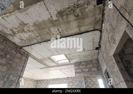 Bau eines einzelnen Wohngebäudes, Blick auf die monolithische Stahlbetondecke im Haus mit einer Öffnung für die Treppe zum Stockfoto