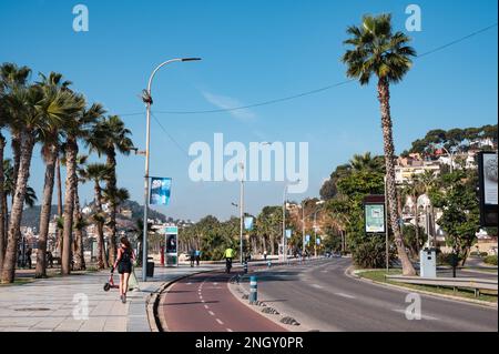 Malaga, Spanien - 14. Januar 2023: Blick auf die Strandstraße mit Menschen, die auf dem Bürgersteig laufen oder Rad fahren Stockfoto