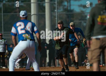 Ein Soldat, der dem 2. Bataillon, 69. Rüstungsregiment, 2. Kampfteam der Panzerbrigade, 3. Infanteriedivision zugeteilt wurde, wird während des Marne Week Softball Tournaments am 1. Dezember 2022 in Fort Stewart, Georgia, in einer Zwickmühle zwischen zwei Soldaten erwischt, die dem 3. Bataillon, 15. Infanterierregiment, 2. ABCT, 3ID zugeteilt wurden. Die Teilnahme an Sportveranstaltungen trug zum Zusammenhalt des Teams und zum Wettkampfgeist bei, was bei der Marne Week 3. in ID von entscheidender Bedeutung ist. Stockfoto