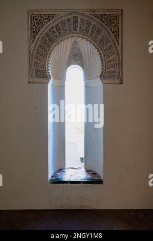 Fenster in die Vergangenheit - kunstvoll verzierte Details im Alcazaba-Palast, einem befestigten Palastkomplex, der eine einzigartige Mischung aus islamischem, spanischem und maurischem Inf zeigt Stockfoto