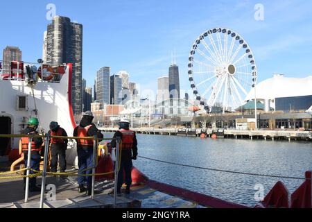 Besatzungsmitglieder an Bord der USCGC Mackinaw (WLBB 30) bewachen die Steuerbordseite des Bojenodecks, während sich der Cutter auf das Anlegen am Chicagoer Navy Pier am 1. Dezember 2022 vorbereitet. Während des Festmachens nimmt die Besatzung Positionen auf dem Fokussierfeld, dem Bojendeck und dem Fantail ein, um eine sichere und effiziente Evolution zu gewährleisten. Stockfoto