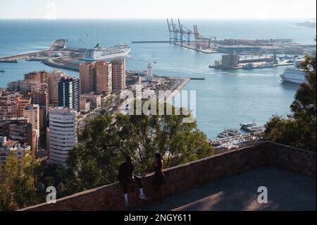 Malaga, Spanien - 15. Januar 2023: Atemberaubender Blick auf Malagas Stadtbild von den Mauern von Castillo de Gibralfaro. Ein paar stehen im Vordergrund, Stockfoto