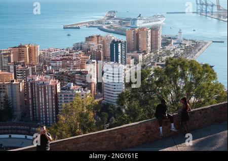 Malaga, Spanien - 15. Januar 2023: Atemberaubender Blick auf Malagas Stadtbild von den Mauern von Castillo de Gibralfaro. Ein paar stehen im Vordergrund, Stockfoto