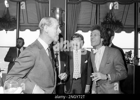 Ein Foto vom 11.05/82, das während des Mittagessens des Variety Club im London Hilton Hotel für den Outward Bound Trust einen Hauch von Pantomime enthielt, anscheinend von Royal Patron, dem Duke of Edinburgh (links) und dem Entertainer Lionel Blair (rechts) der TV-Pantomime-Show „Gib uns einen Hinweis“ erlassen. Zu sehen sind die Sportkommentatorin Dickie Davies (Schnurrbart) und der Schauspieler Sir John Mills (teilweise versteckt). Die ehemalige Moderatorin der World of Sport, Dickie Davies, ist im Alter von 94 Jahren gestorben. Davies war vor allem bekannt für die Verankerung der ITV-Sportshow von 1968 bis zum Ende 1985. Ausgabedatum: Sonntag, 19. Februar 2023. Stockfoto