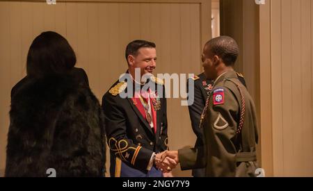 USA Armeekollege Daniel C. Gibson, Kommandeur der Division Artilleriebrigade (DivArty), 82. Luftwaffendivision schüttelt sich beim Ball zum St. Barbara's Day in Pinehurst, North Carolina, am 2. Dezember 2022 die Hand mit einem Fallschirmjäger. Der Orden der heiligen Barbara ist eine Tradition, die durch die offizielle Feier und Verleihung von Preisen zu Ehren der heiligen Barbara, dem Schutzpatron der Artillerie, anerkannt wird. Stockfoto