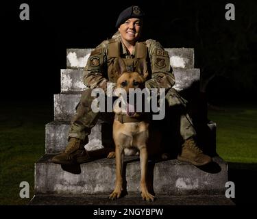 USA Air Force Staff Sgt. Shanna McCarter, 18. Security Forces Squadron, militärischer Hundeführer, posiert für ein Foto mit MWD Dina am Kadena Air Base, Japan, 1. Dezember 2022. McCarter war mehrere Jahre lang Polizistin, bevor sie zur Air Force kam. Sie sagte, sie wolle weiterhin Polizistin sein, weil sie gerne der Gemeinde hilft und sie beschützt. Stockfoto