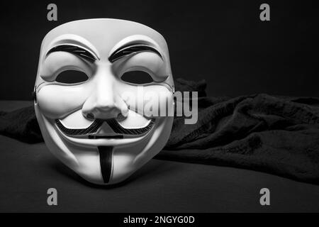 Eine Maske der Anonymen mit schwarzem Tuch und schwarzem Hintergrund Stockfoto