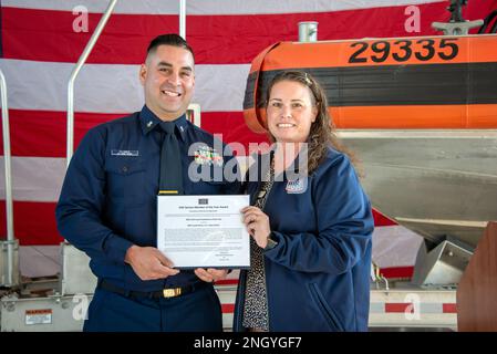 Coast Guard Petty Officer 2. Class Jake Flores, Experte für die Durchsetzung der Seeschifffahrt beim Maritime Safety & Security Team Houston und 2022 USO Service Member of the Year Honoree, akzeptiert ein Zertifikat von Lorén Westerfield, Executive Director von USO Houston & South Texas, während einer Zeremonie in Houston, Texas, am 1. Dezember 2022. Flores' Kommando nominierte ihn für den Preis, weil er während einer Patrouille am 2. Juni 2022 in den Rio Grande gesprungen ist, um ein ertrinkendes Baby zu retten. Stockfoto