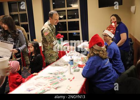 Mitglieder der Installations-Community nehmen am 1. Dezember 2022 an den Festivitäten des 2022. Fort McCoy Christmas Tree Lighting Event im McCoy's Community Center in Fort McCoy, Wisconsin, Teil. Dutzende Mitglieder der Fort McCoy Community strömten ins Zentrum, um an der Veranstaltung teilzunehmen. Es war die größte Ausstellung seit 2019. Die Veranstaltung umfasste nicht nur die Beleuchtung der Bäume, sondern auch Kunsthandwerk für Kinder, Fotos mit dem Weihnachtsmann und seiner Frau, kostenlose heiße Schokolade und Kekse und andere Aktivitäten. Die jährliche Veranstaltung ist der Startschuss der Anlage in die Weihnachtszeit. Stockfoto