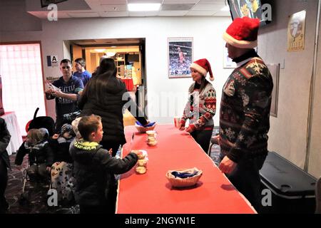 Mitglieder der Installations-Community nehmen am 1. Dezember 2022 an den Festivitäten des 2022. Fort McCoy Christmas Tree Lighting Event im McCoy's Community Center in Fort McCoy, Wisconsin, Teil. Dutzende Mitglieder der Fort McCoy Community strömten ins Zentrum, um an der Veranstaltung teilzunehmen. Es war die größte Ausstellung seit 2019. Die Veranstaltung umfasste nicht nur die Beleuchtung der Bäume, sondern auch Kunsthandwerk für Kinder, Fotos mit dem Weihnachtsmann und seiner Frau, kostenlose heiße Schokolade und Kekse und andere Aktivitäten. Die jährliche Veranstaltung ist der Startschuss der Anlage in die Weihnachtszeit. Stockfoto