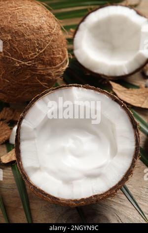 Reife Kokosnuss mit Sahne auf einem Holztisch, Blick über die Kulisse Stockfoto