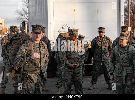 USA Marinekorps Sgt. Joshua Smith, ein Supply Admin and Operations Specialist, der dem Combat Logistics Battalion zugewiesen ist - 453, 4. Marine Logistics Group, gibt einleitende Bemerkungen zum „Toys for Tots Foot March“, bevor er am 2. Dezember 2022 auf den Manhattan Town Square in Manhattan, Kansas, aufmarschiert. Smith sowie mehrere andere Marines, ein Matrose und ein Soldat, halfen bei der Organisation des fußmarsches im Namen der Gemeinde. Stockfoto