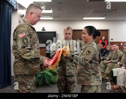 Der stellvertretende Befehlshaber des Militärmaterialkommandos und Redstone Arsenal Oberbefehlshaber LT. General Chris Mohan entfaltet die drei-Sterne-Flagge, unterstützt von Sergeant Major Samara Pitre und Sergeant 1. Klasse Robert Peters während seiner Beförderungszeremonie. Stockfoto