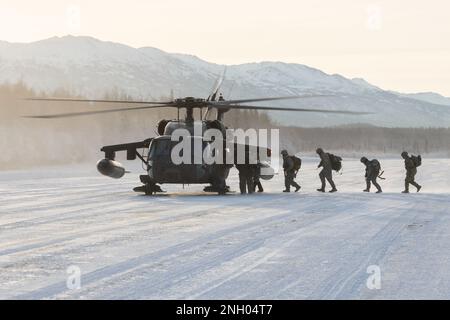 Die ROTC-Kadetten der University of Alaska Army gehen an Bord eines Alaska Army National Guard UH-60L Black Hawk Helikopters, der dem 1-207. Aviation Regiment zugeteilt wurde, während einer Flugübungsveranstaltung auf der Joint Base Elmendorf-Richardson, Alaska, 2. Dezember 2022. Nach der taktischen Insertion manövrierten die Seawolf-Truppenkadetten über schneebedecktes Gelände, griffen Oppositionstruppen an, sicherten sich ihr Ziel und beendeten sie mit einer Luftextraktion. Das General Support Aviation Battalion der AKARNG bildet routinemäßig mit allen Zweigen des Militärs sowie mit zivilen Organisationen zusammen, um seine operative Verbindung zu verbessern Stockfoto