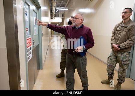 Edward Conway, Programminspektor für Bestattungsangelegenheiten bei der Air Force Mortuary Affairs Operations, zeigt den Beamten der 436. Medical Group Flight Medicine Division eine Karte für persönliche Schutzausrüstung außerhalb der Kleidungs- und Restaurierungsabteilung während eines Rundgangs der AFMAO auf der Dover Air Force Base, Delaware, 2. Dezember 2022. Stockfoto