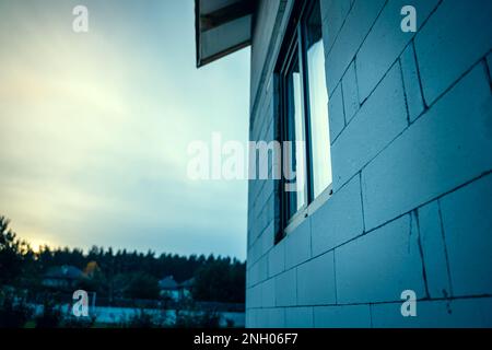 Ein Blickwinkel eines frisch gebauten privaten Hauses aus Porenbeton am späten Abend. Gebäude in einem privaten Sektor Stockfoto