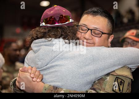 Ein Soldat der Oklahoma Army National Guard umarmt ein Familienmitglied bei der Einsatzzeremonie für Hauptquartier Battery, 45. Artilleriebrigade in Mustang, Oklahoma, 3. Dezember 2022. Die Soldaten entsenden in das Verantwortungsgebiet des US-Zentralkommandos und bieten Hauptquartier-Operationen zur Planung und Durchführung unterstützender Brände an. (Fotos der Oklahoma Nationalgarde von SPC. Danielle Rayon) Stockfoto