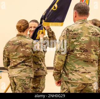 JOINT BASE LEWIS-McChord, Washington Kommandoleiter Major Melissa D. Vine (Zentrum), der neue hochrangige, konkurrierte Berater, 1-364., Training Support Bataillon, 189. Infanteriebrigade, akzeptiert den Bataillonsleitfaden vom Kommandeur des Bataillons, Oberstleutnant Kristy Norquist, während einer Zeremonie zum Verantwortungswechsel in Schwab Army Reserve Center, Joint Base Lewis-McChord, Washington, 4. Dezember 2022. Stockfoto