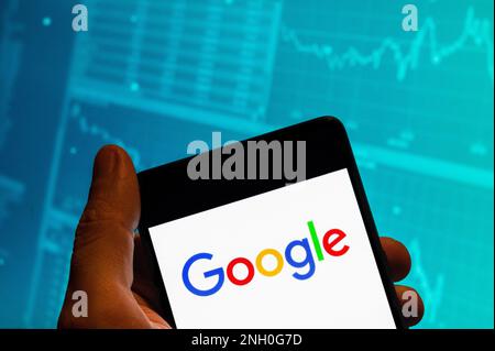 China. 15. Februar 2023. In dieser Fotoabbildung wird das Logo des amerikanischen multinationalen Technologieunternehmens und der Suchmaschine Google (Alphabet, Inc) auf einem Smartphone mit einem Diagramm des Börsenindex im Hintergrund angezeigt. (Foto: Budrul Chukrut/SOPA Images/Sipa USA) Guthaben: SIPA USA/Alamy Live News Stockfoto