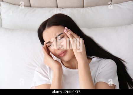 Junge Frau mit Migräne im Bett, über Sicht Stockfoto