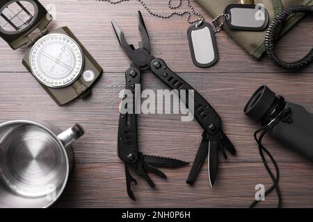 Flache Verlegung mit kompaktem tragbarem Multitool und Zubehör auf Holztisch Stockfoto