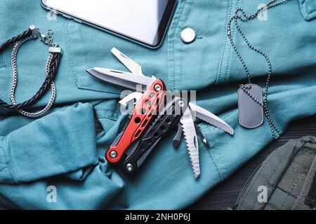Flache Verlegung mit kompaktem tragbarem Multitool und Zubehör auf dem Tisch Stockfoto