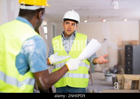 Vorarbeiter unzufrieden mit der Qualität der Reparaturarbeiten der Baumeister Nahaufnahme Stockfoto