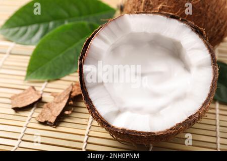 Reife Kokosnuss mit Sahne auf Bambusmatte. Platz für Text Stockfoto