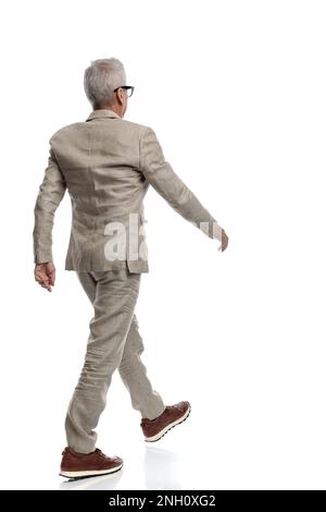 Rückansicht eines eleganten alten Mannes im Anzug vor weißem Hintergrund Stockfoto