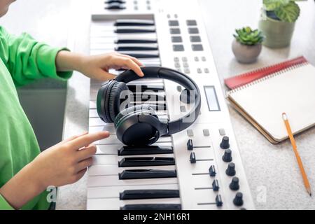 Nahaufnahme, schwarze Kopfhörer in den Händen eines Kindes, Musikkonzept. Stockfoto