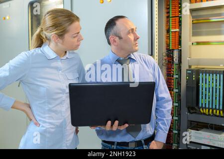 Team von Technikern, die an Servern zusammenarbeiten Stockfoto