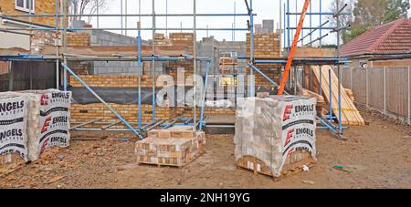 Zugangsleiter aus Holz durch spezialisierten Unterauftragnehmer für Gerüste für Mauerwerk zur Arbeit an nach außen gerichteten Ziegelsteinen und Blockwänden in England UK Stockfoto