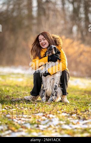 Junge Teenager spielen mit ihrem Hund in der Natur. englischer Setter Stockfoto