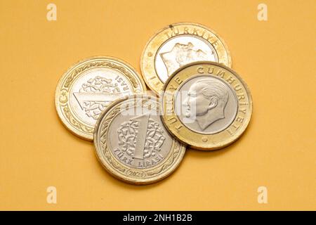 Vorder- und Rückansicht einer türkischen Lira-Münze aus dem Jahr 1 auf gelbem Hintergrund. Stockfoto