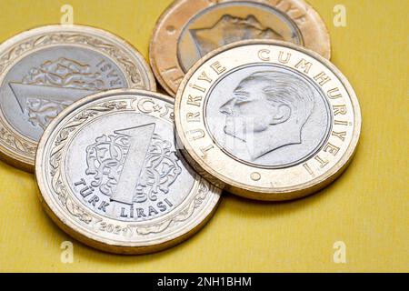 Vorder- und Rückansicht einer türkischen Lira-Münze aus dem Jahr 1 auf gelbem Hintergrund. Stockfoto