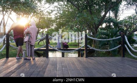 Der Sonnenuntergang im öffentlichen Park ist wie im Kino, wenn Hidschab-Frauen Zeit miteinander verbringen und Selfie-Fotos machen Stockfoto