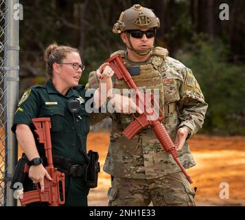 Field Training Officer Sarah Warwick, Walton County Sheriff's Department, informiert einen 96. Sicherheitsstaffelflugmann während einer aktiven Angriffsübung am 6. Dezember auf dem Luftwaffenstützpunkt Eglin, Florida. Die Übung, an der Schüler der EOD-Schule der Navy beteiligt waren, fand tief im Eglin-Bereich statt. Die Übung testete die Reaktionsfähigkeit des 96. Testflügels, der Strafverfolgungsbehörden von Okaloosa und Walton County, der Feuerwehr und des medizinischen Personals. (USA Air Force Photo/Samuel King Jr.) Stockfoto