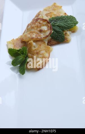 Frisch gebackene Kekse sind verstreuter Puderzucker. Shortbread-Teig, Shortcake-Backen. Backwaren. Große weiße rechteckige Platte hochwertige FullHD-Aufnahmen Stockfoto