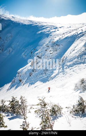 Schneebedeckte Tuckerman-Schlucht mit Skifahrer, die rechts in die Schlucht fahren Stockfoto