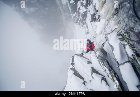 Eiskletterer, die einen steilen Abschnitt von Felsen und Eis besteigen Stockfoto
