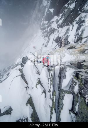 Ice climber mixed climbing a steep section of rock and ice Stock Photo